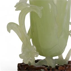 Chinese green jade magnolia form vase, supported on a leafy stem, with flowers and butterflies, on a pierced and carved hardwood stand, H15cm x W14cm