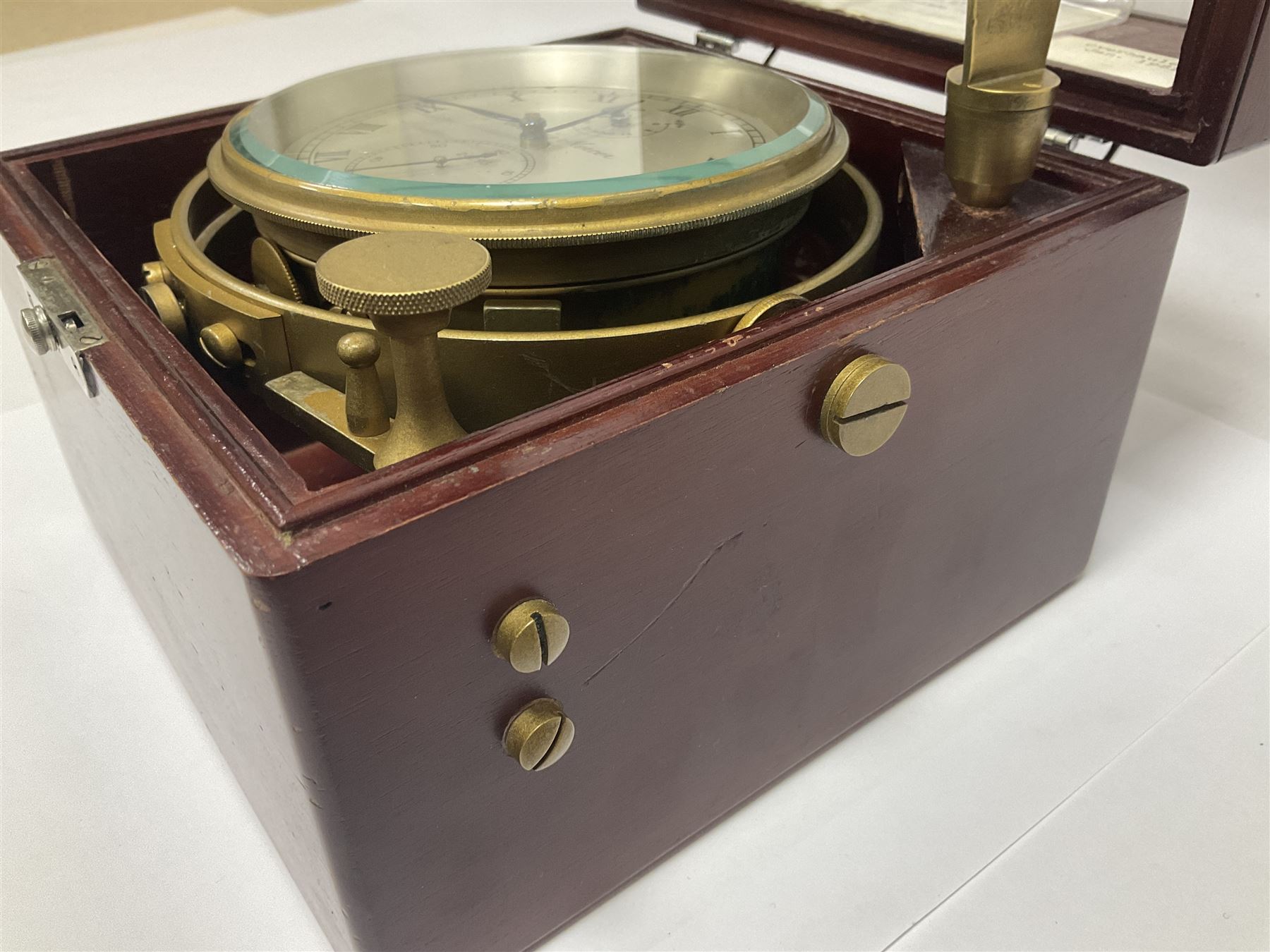 Two-day marine chronometer, with silvered dial inscribed Thomas Mercer Ltd, St Albans, contained within a brass gimbal-mounted bowl and glazed mahogany case, with applied brass plaque reading 'supplied by Kelvin Hughes no. 24295', brass winding key and two service notes to interior of case, dial D12cm, wooden case H17.5cm 