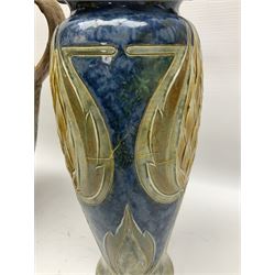 Early 20th century Royal Doulton stoneware vase, decorated with a stylized floral design below a wavy rim, monogrammed B.N, possibly for Bessie Newbery, H28cm, together with an early 20th century glazed jug, heavily carved throughout (2)