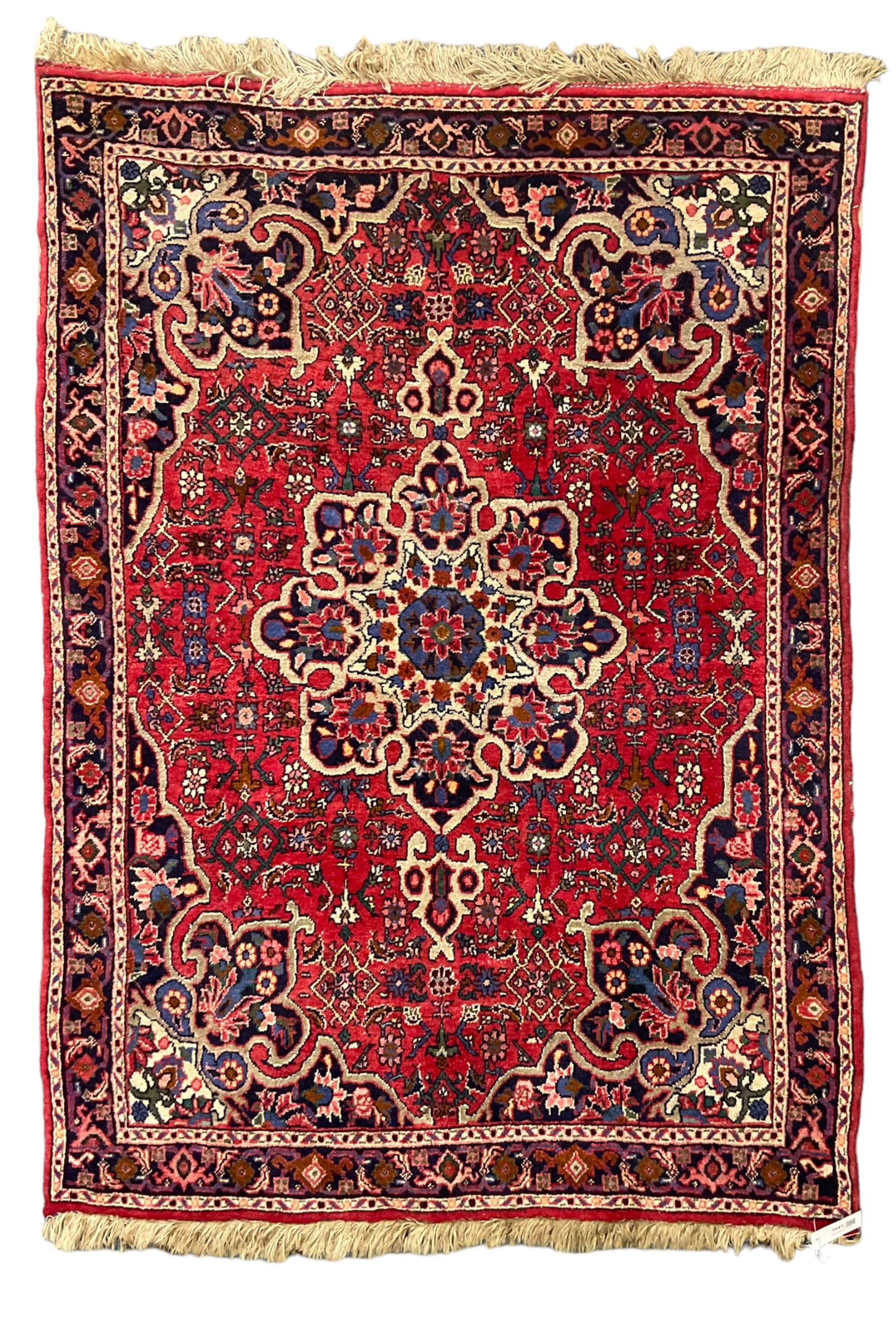 Persian Hamadan crimson ground rug, central floral pole medallion with matching spandrels, the guarded indigo border with interlaced palmettes