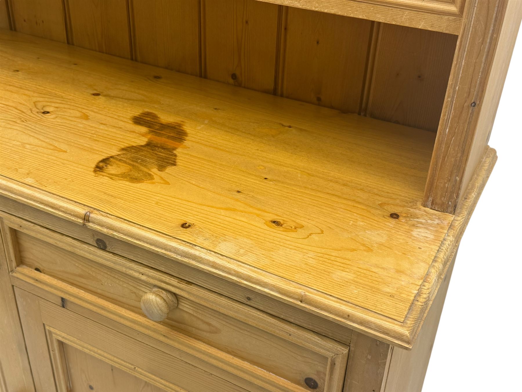 Traditional design waxed pine dresser, upper section with moulded cornice over scalloped frieze, fitted with two open shelves and four drawers, lower section with three drawers over three panelled cupboards, on plinth base