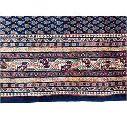 Large North-West Persian Arrak indigo ground carpet, the field decorated all-over with small Boteh motifs, multiple band border decorated with repeating geometric designs