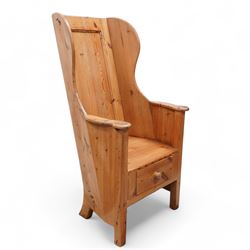 20th century waxed pine lambing chair, winged panelled back, shaped arms enclosing plank s...