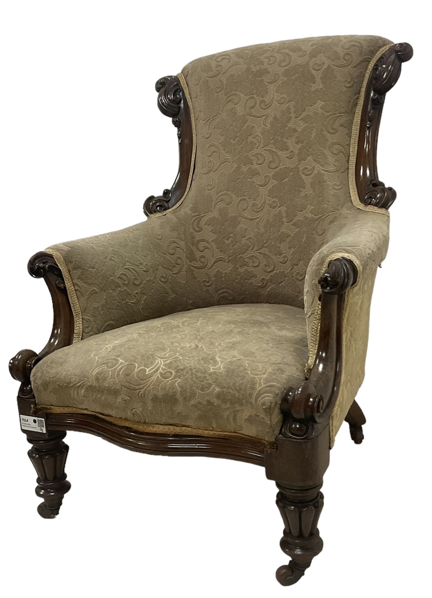 William IV mahogany framed armchair, rolled back with scroll carved uprights, acanthus carved arm terminals over serpentine fronted seat, raised on turned and lobe carved supports with castors