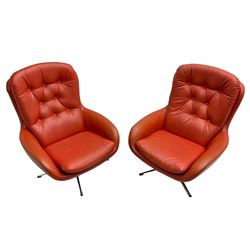 Pair mid-20th century circa.1974 swivel lounge chairs upholstered in buttoned red faux leather, on polished metal base