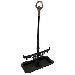 Black painted cast iron boot scraper with handle, decorated with scroll work with shaped tray 