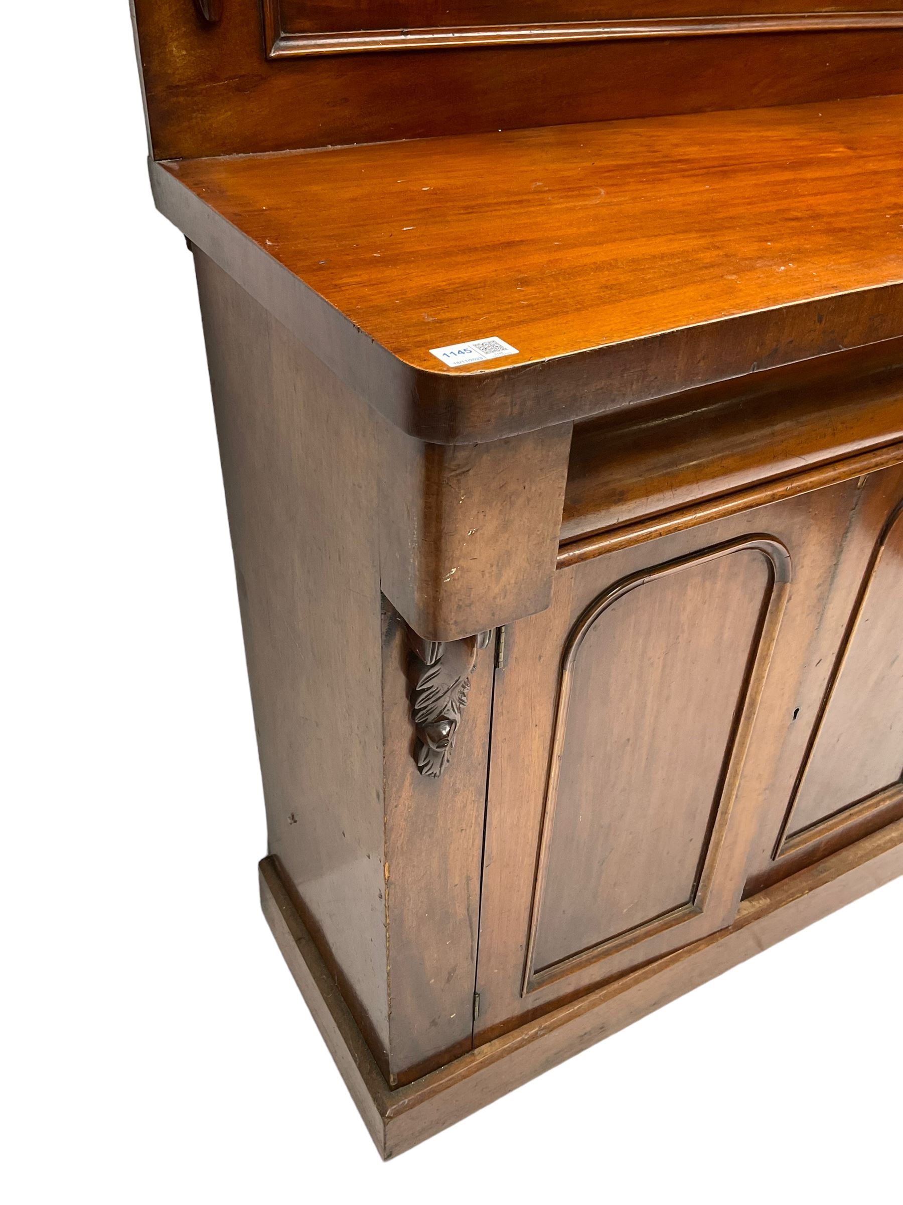 Victorian mahogany chiffonier, raised back with carved C-scroll foliage mounts and shelf, rectangular top with rounded corners over frieze drawer and double panelled cupboard, on skirted base