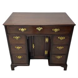 George III mahogany kneehole desk, moulded rectangular top over one long drawer, six short drawers and recessed panelled cupboard, cock-bead moulded frame, fitted with shaped brass handle plates with engraved decoration, on bracket feet 