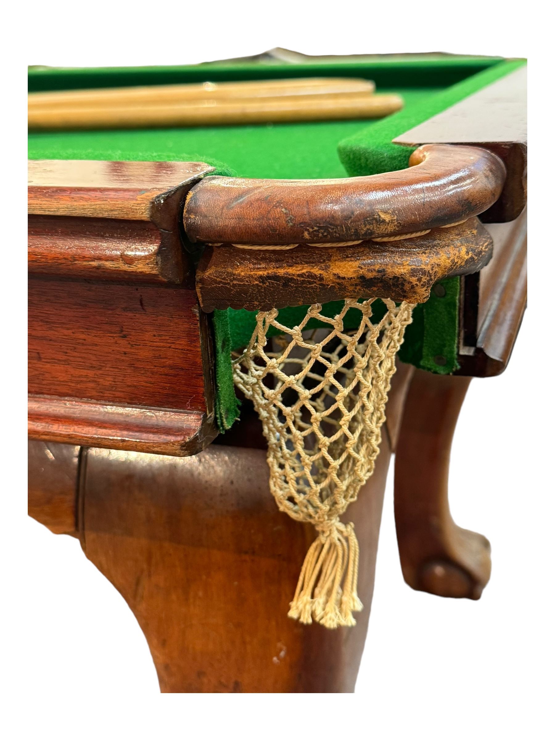 Riley - mahogany slate bed snooker dining table, green baize playing surface fitted with leather net pockets, raised on cabriole supports ending in ball and claw feet; together with set of Riley cues, balls and scoreboard