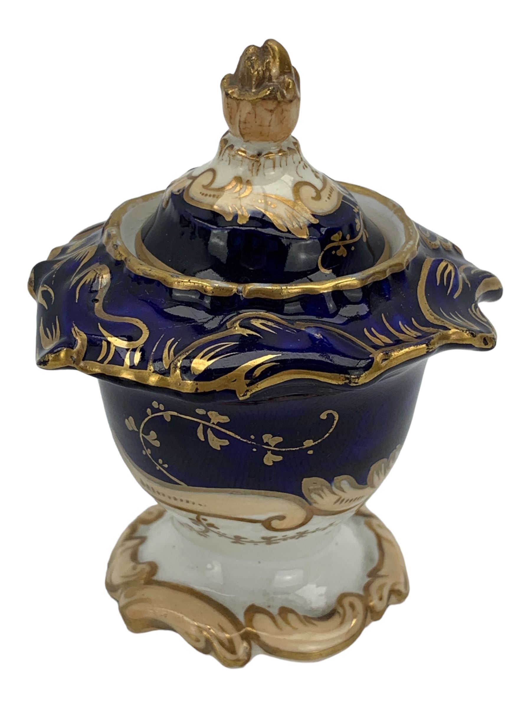 19th century porcelain inkstand, the oblong twin handled base centrally painted with a floral bouquet, flanked by two footed inkwells and covers, with rococo-inspired acanthus moulded borders and handles, pattern no. 2/3339, L26.5cm 