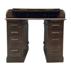 Early 20th century oak twin pedestal roll top desk, tambour roll enclosing fitted interior, each pedestal fitted with four drawers and slide, on plinth base 