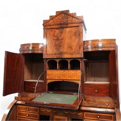 19th century Biedermeier figured mahogany cylinder bureau cabinet, the raised super structure with stepped pointed pediment over hidden cupboard and hinged fall front, the interior fitted with pigeonholes and secret drawers behind rusticated inlay, curved flanking cupboards fitted with internal drawers, the cylinder top opens to reveal small drawers, document divisions and secret compartments, sliding desk with central hinged writing surface, inlaid with satinwood bands and draped festoons, fitted with three long drawers, on bracket feet