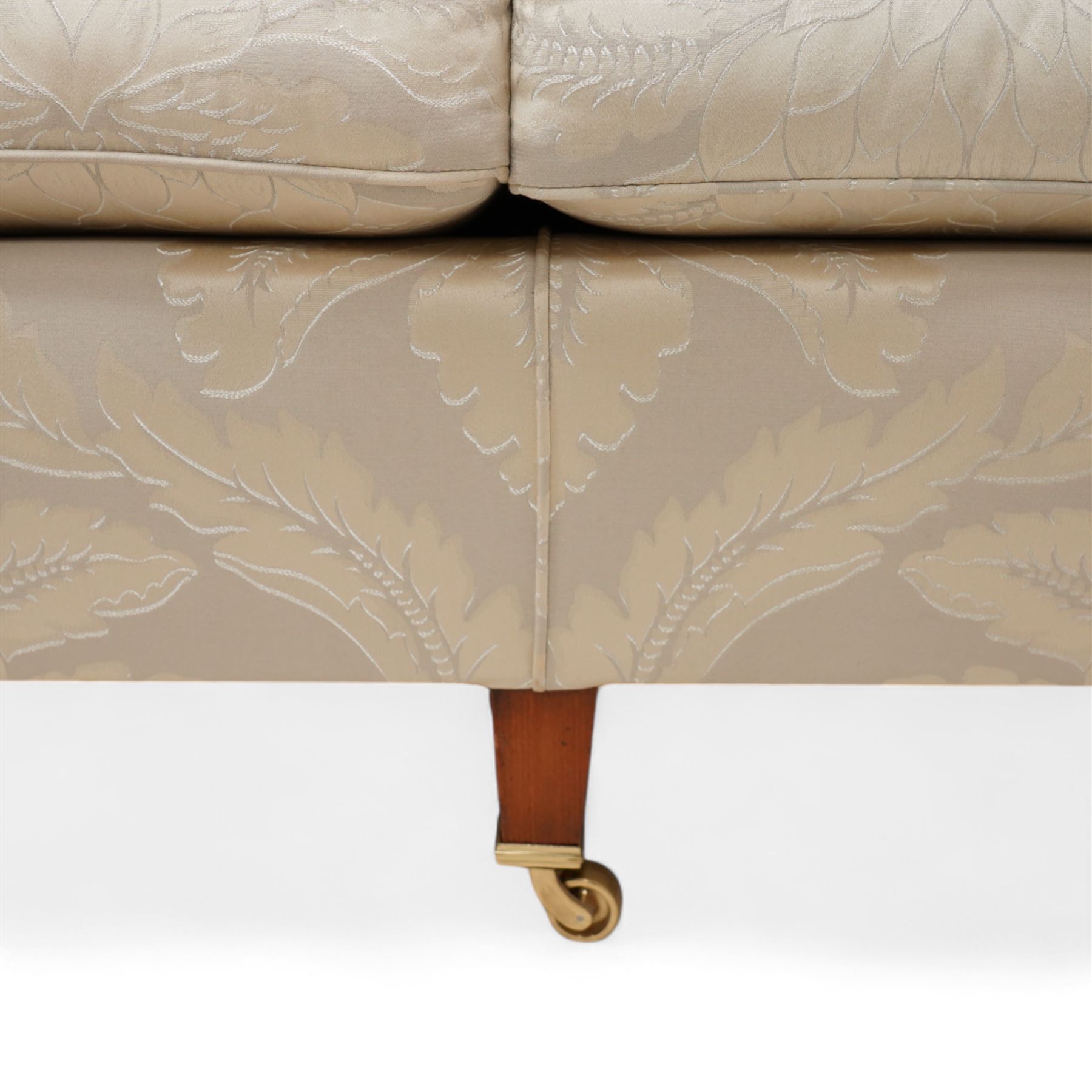 Duresta - Grande hardwood-framed three-seat sofa, upholstered in pale fabric decorated with repeating foliate pattern, on square tapering supports with brass castors 