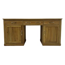 Contemporary light oak twin pedestal desk, fitted with three drawers over two cupboards with chrome handles, the central drawer with hinged front panel revealing pull-out keyboard tray, on plinth base