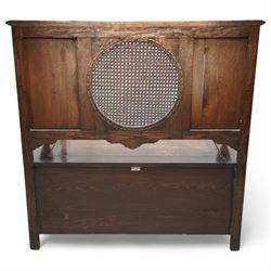 Early 20th century oak hall bench, circular caned back enclosed by panels decorated with flowerhead carved arcades, hinged box seat, panelled front 