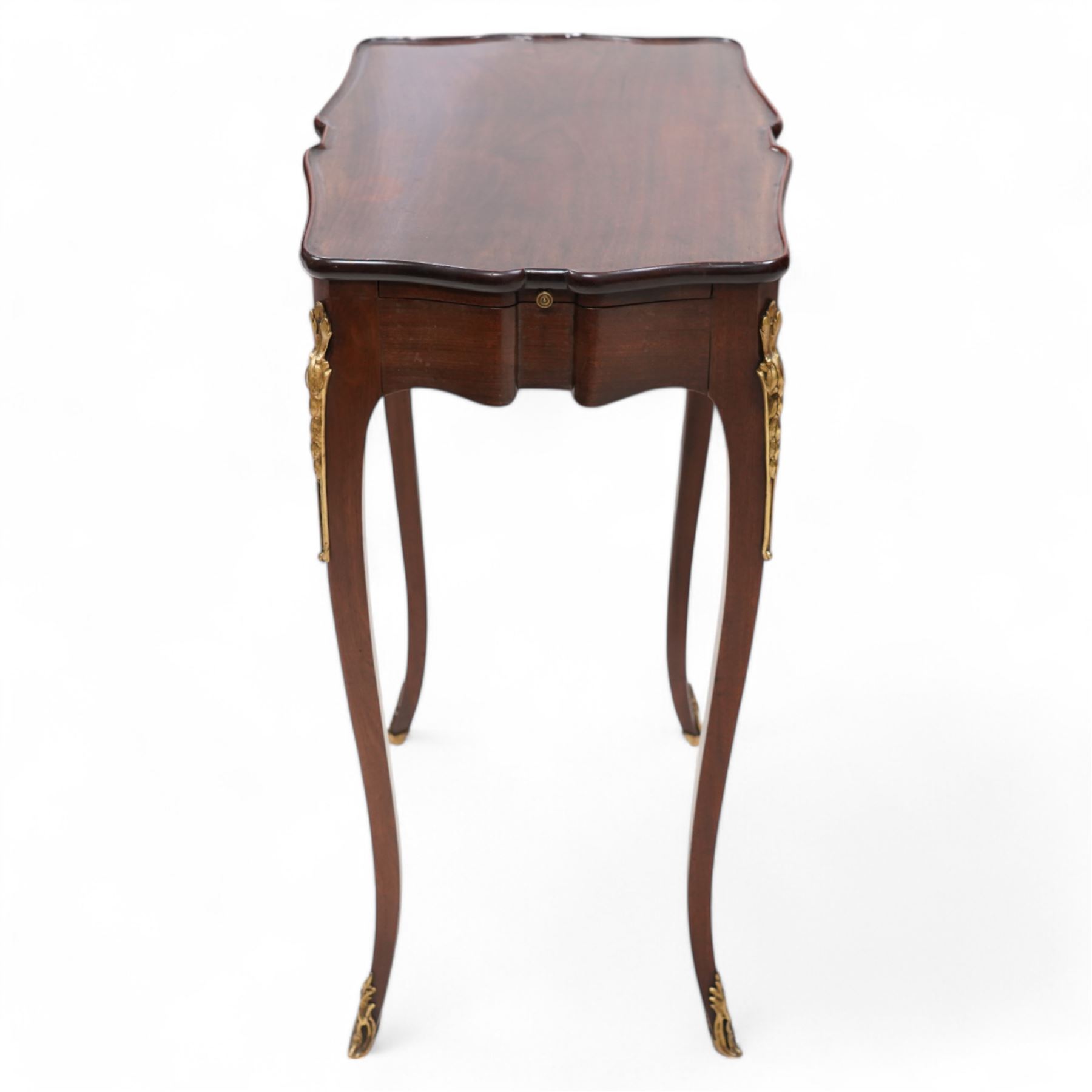 Mid-to-late 20th century French mahogany side table, shaped form with lipped top, single end drawer and opposing slide, on gilt metal mounted cabriole supports 