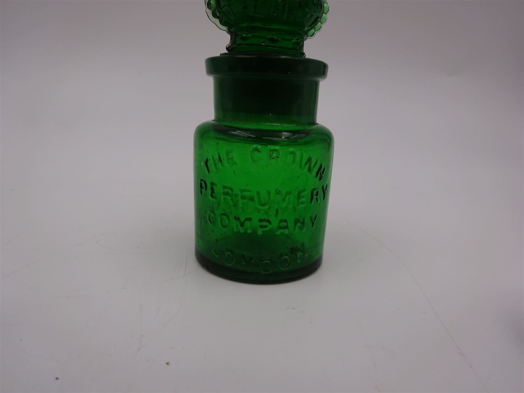 Edwardian silver mounted green glass scent bottle, with embossed silver sleeve and crown finial to stopper, the glass body marked 'The Crown Perfumery Company London', silver sleeve hallmarked Arthur Willmore Pennington, Birmingham 1903