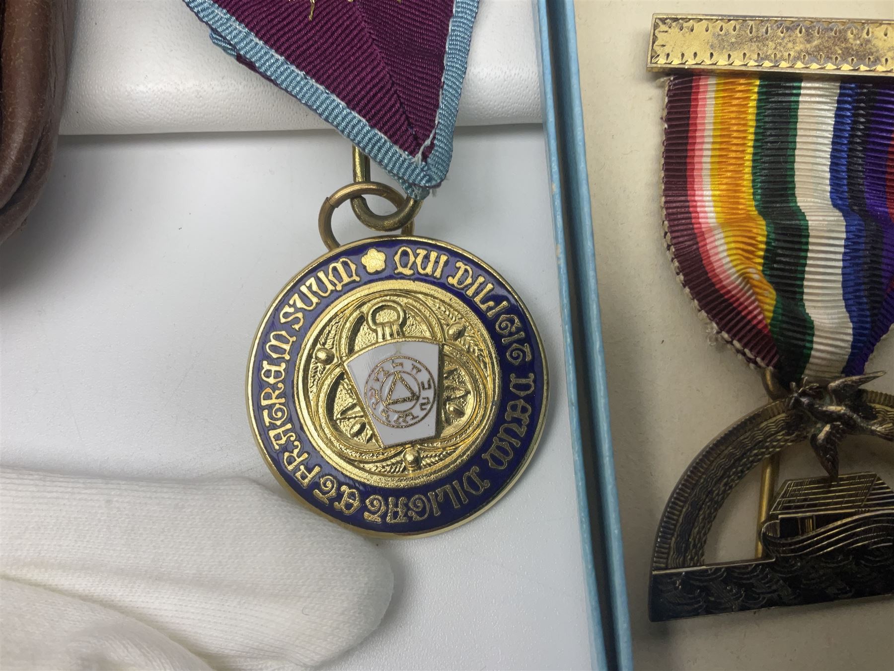 Masonic regalia, including two silver-gilt medals/jewels, centenary medal, aprons, and sash etc, housed in brown briefcase