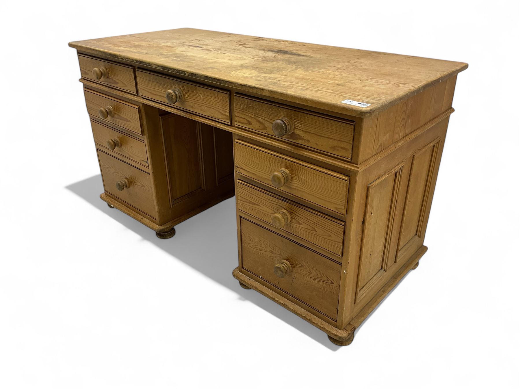 Waxed pine twin pedestal desk, rectangular top over nine drawers, on compressed bun feet 