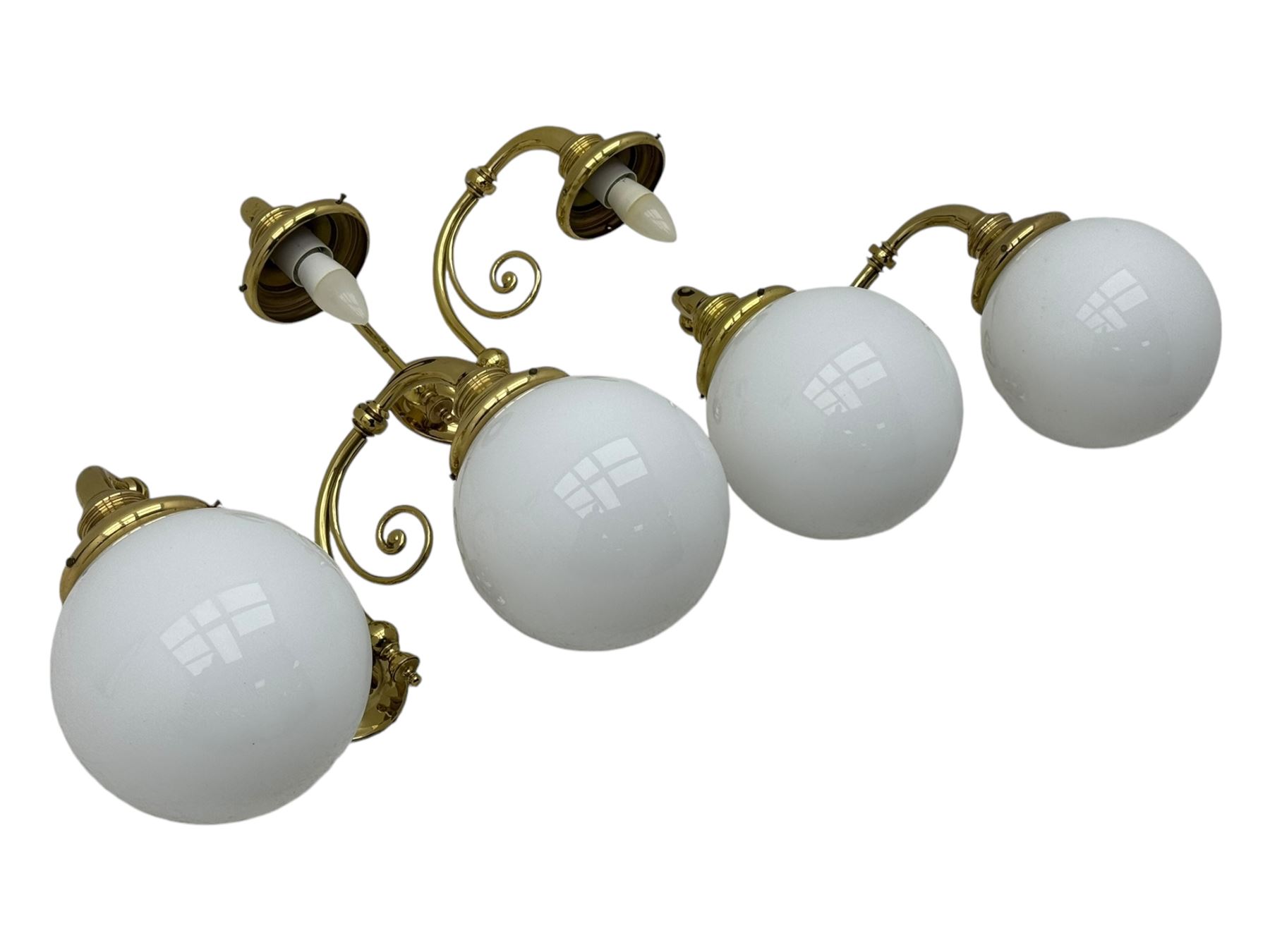 Two brass double-arm wall mounted lights, each with frosted glass globes and scrolled arms (W50cm, D26cm, H31cm); matching central double-arm light with candle-style fittings (W42cm, D24cm, H22cm)