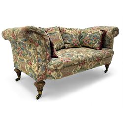 Mid-19th century walnut framed two-seat sofa, rolled arms over sprung seat, single drop-end action, raised on turned and fluted feet with brass cups and castors, upholstered by E & S Gott in traditional floral pattern fabric decorated with urns