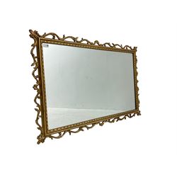 Ornate gilt framed mirror, decorated with trailing and scrolled foliage, plain mirror plate