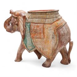 Early 20th century Indian hardwood and polychrome Elephant jardiniere stand, decorated with a headdress and vibrant saddle cloths, surmounted by an octagonal shaped saddle, with overall craquelure finish