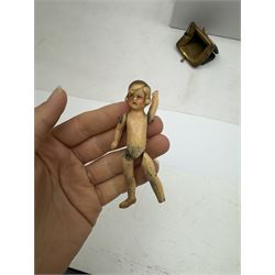 Four miniature dolls with articulated limbs, and a miniature purse