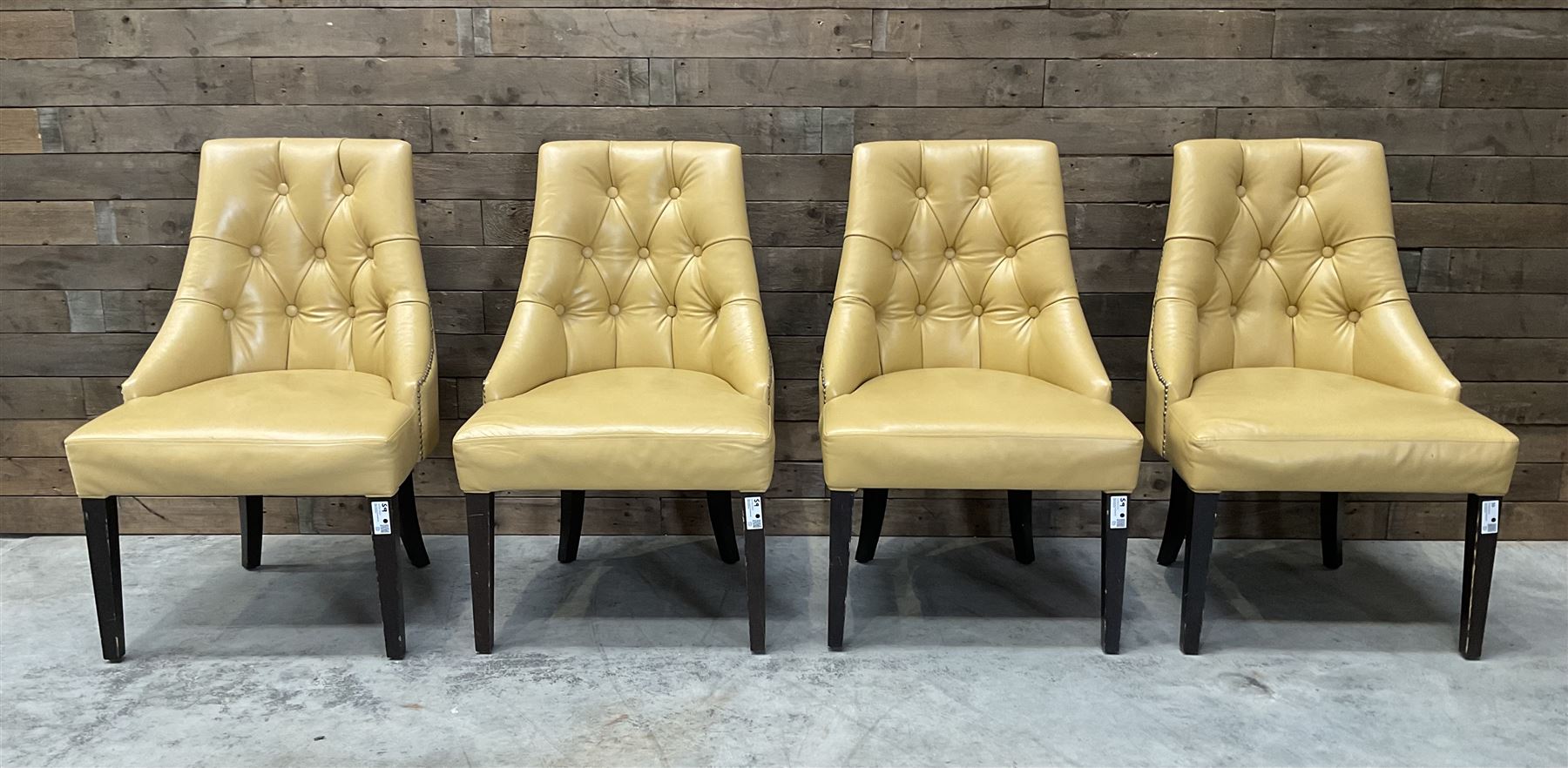 Four high back chairs upholstered in buttoned beige leather, studded detail, rosewood legs