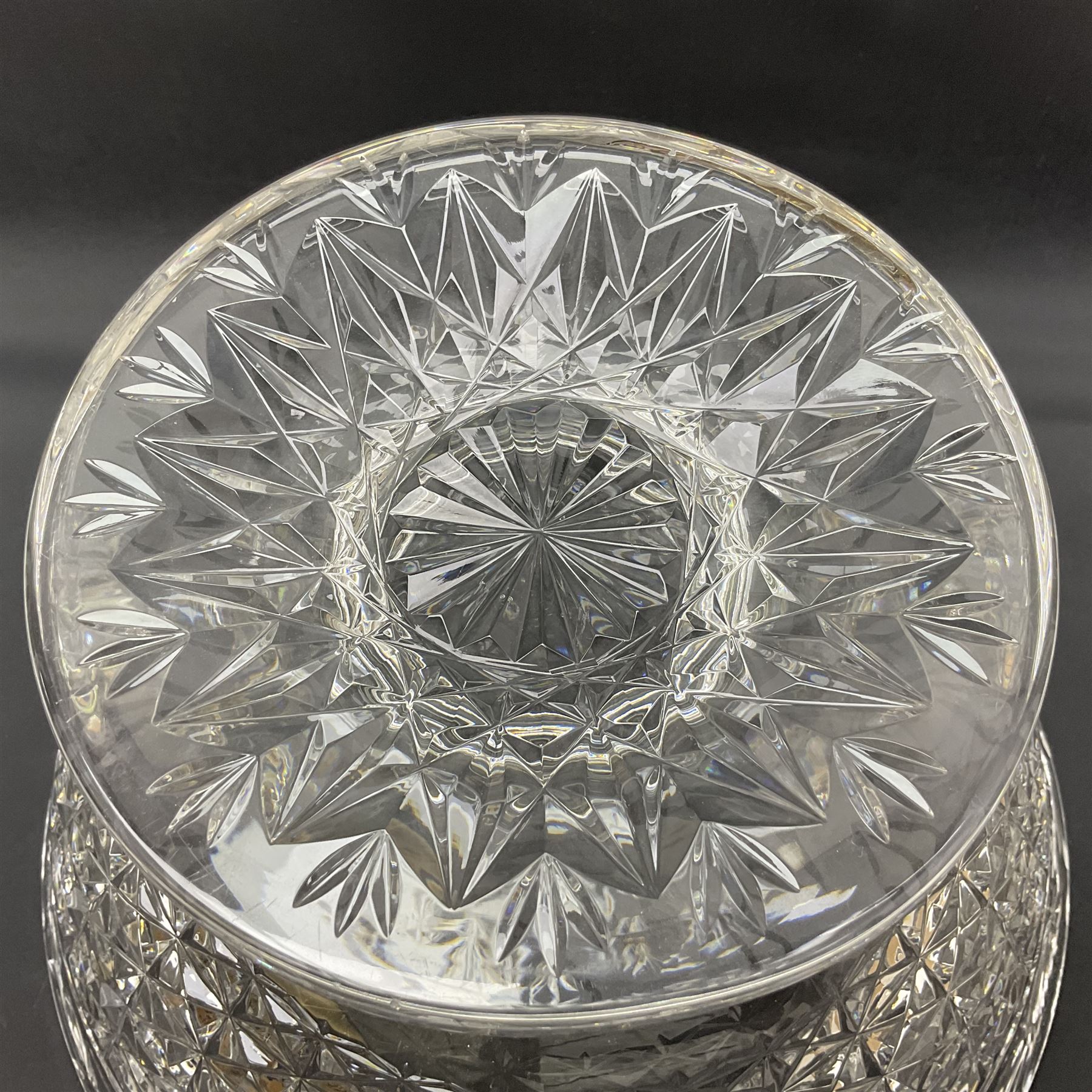 Large Stuart crystal pedestal punch bowl, of circular form, the rim with engraved floral decoration, upon spreading circular foot with radial cut decoration, with seven matching Stuart crystal drinking glasses, each with a C handle, each acid signed beneath, bowl H20cm