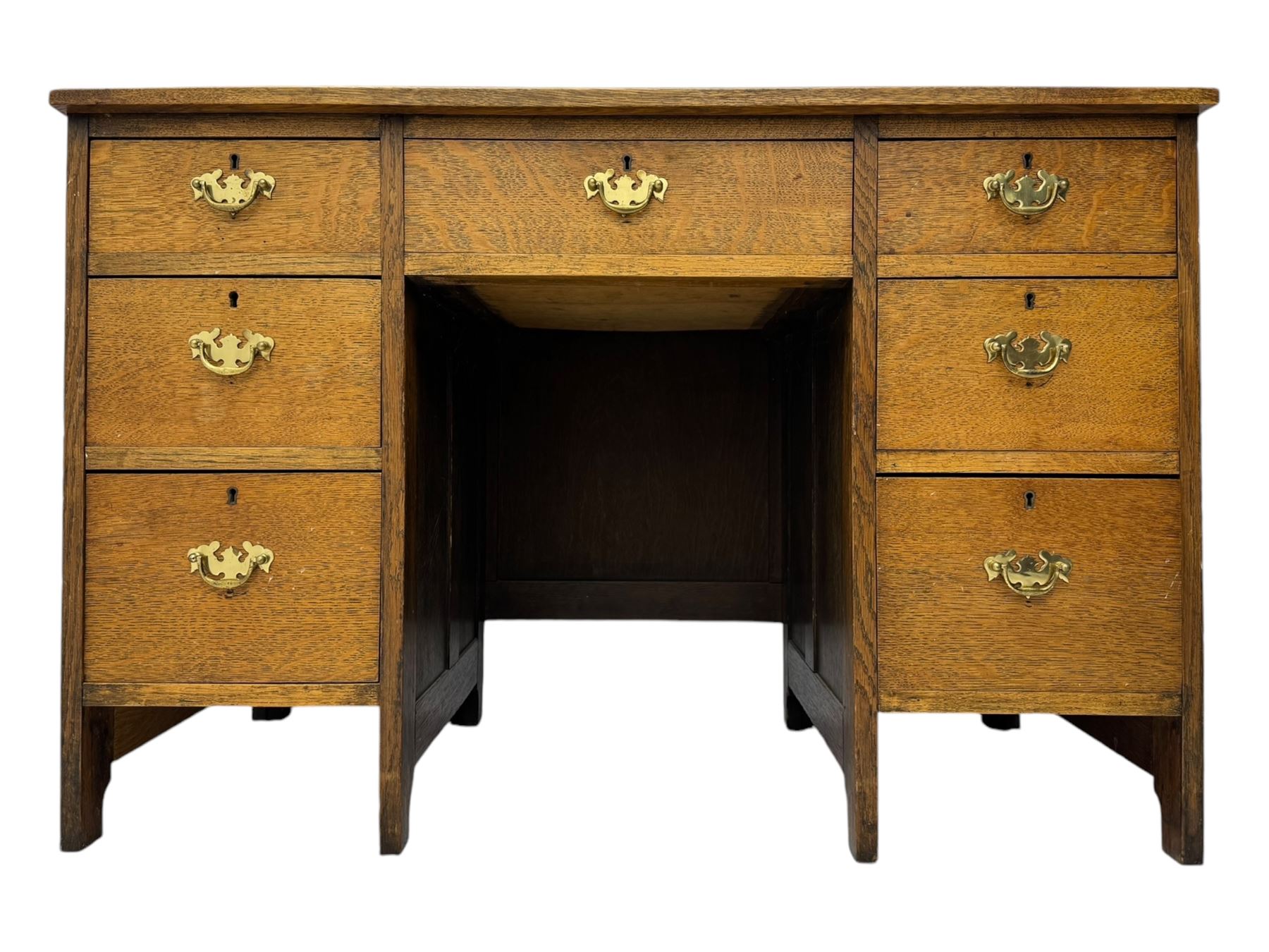 Edwardian oak twin pedestal desk, moulded rectangular top with inset writing surface, fitted with seven drawers, panelled sides, on stile supports 