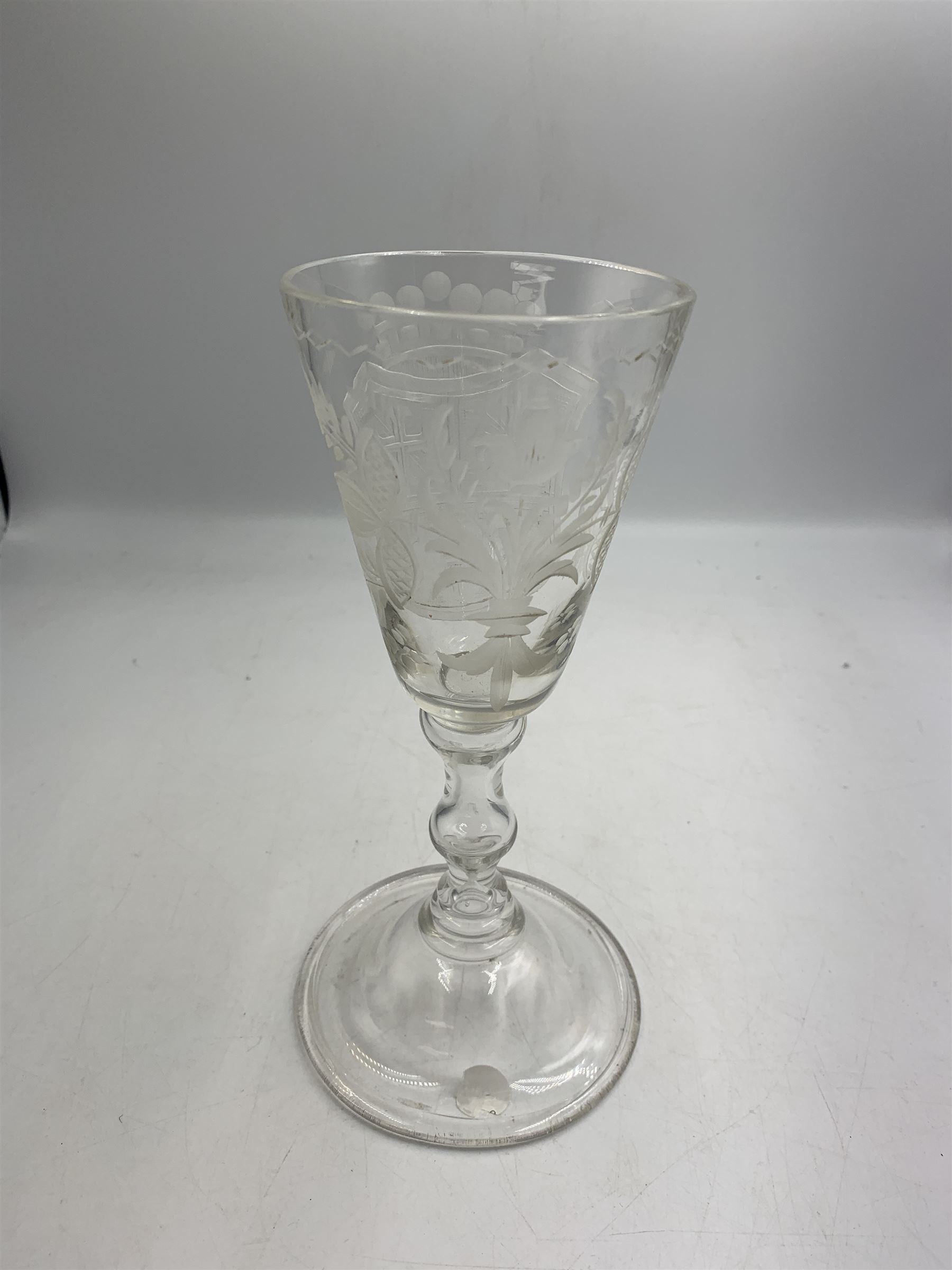 18th century large baluster wine glass, circa 1745, the funnel bowl decorated with a crest and foliate, to a knopped stem and deep domed  and upturned foot, H20cm