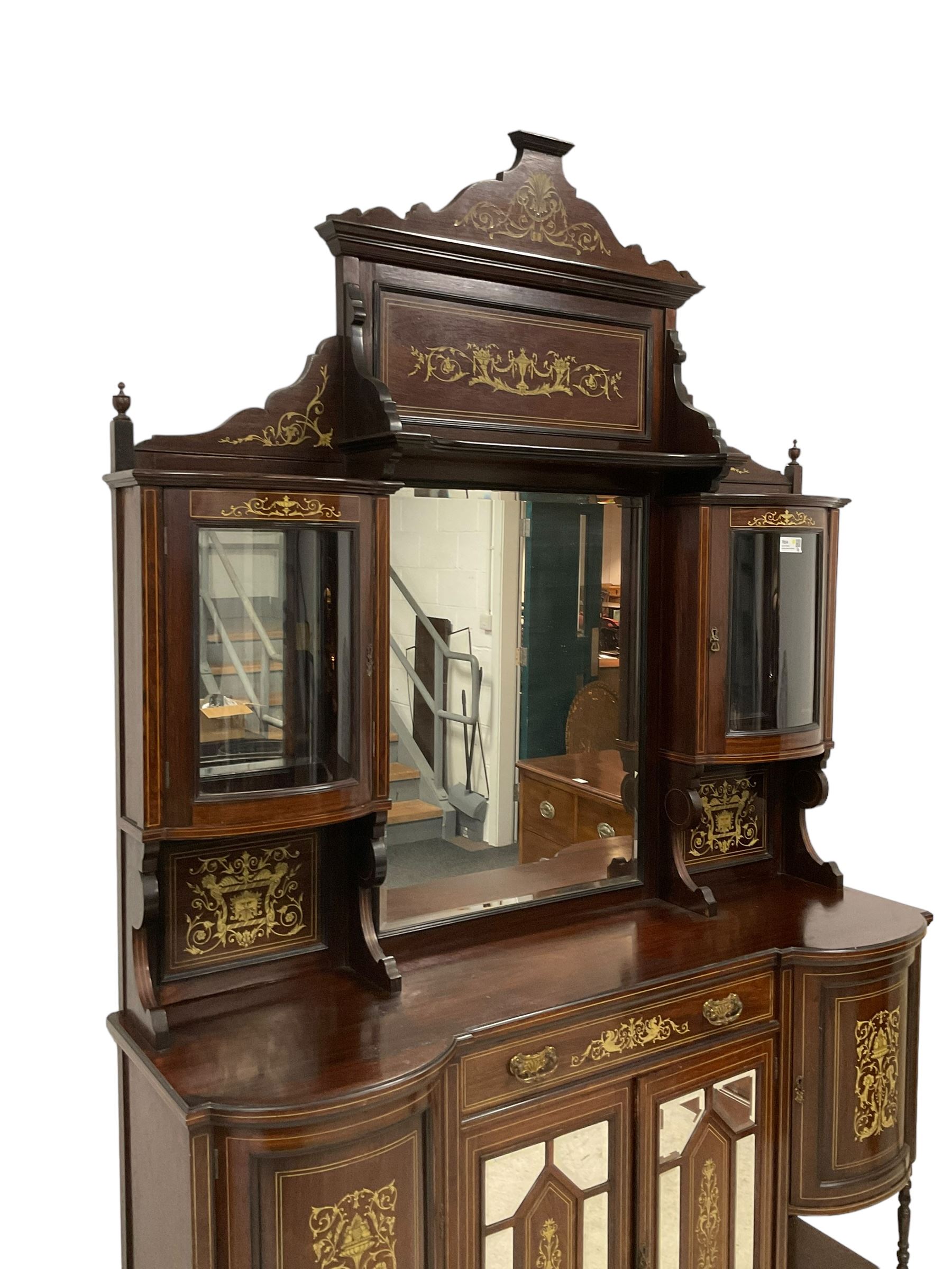 Late Victorian inlaid rosewood mirror back sideboard, shaped cresting rail decorated with scrolling foliate ivorine inlays, over rectangular bevelled mirror, flanked by bow-front glazed cupboards over inlaid 'green man' motifs, the base fitted with single drawer and cylindrical cupboards flanking a mirror panelled cupboard, on square tapering supports