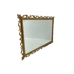 Ornate gilt framed mirror, decorated with trailing and scrolled foliage, plain mirror plate