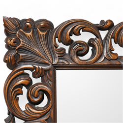 Early 20th century walnut framed wall mirror, bevelled mirror plate enclosed by carved frame, decorated with curling foliage 