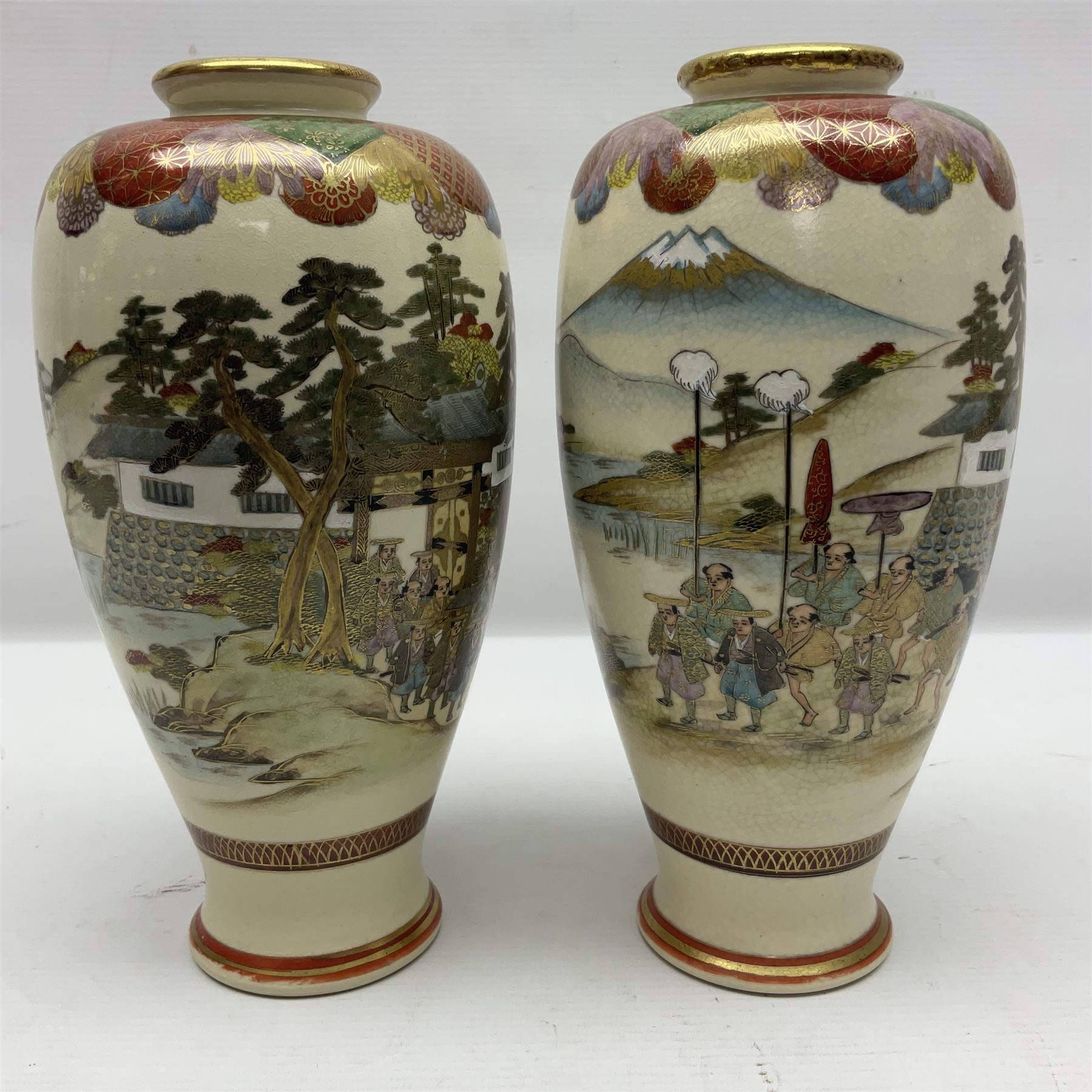 Pair of Japanese Meiji period Satsuma vases, decorated with scenes of procession within a mountainscape, with signature beneath, H25cm