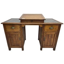 Edwardian pitch pine desk, rectangular top with writing slope flanked by inset leather writing surfaces, over twin pedestals each with shell cup handled drawer over cupboard, the left enclosing two shelves, the right enclosing sliding trays, on fluted straight supports