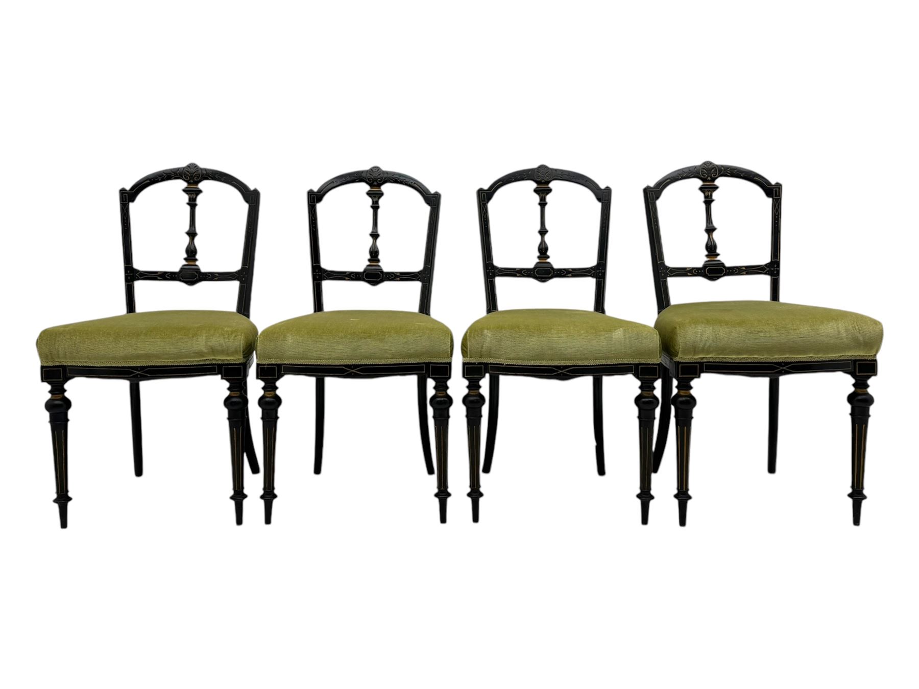 Set of four late Victorian ebonised dining chairs, decorated with carved and gilt foliate decoration, upholstered seats, on turned and fluted front supports 