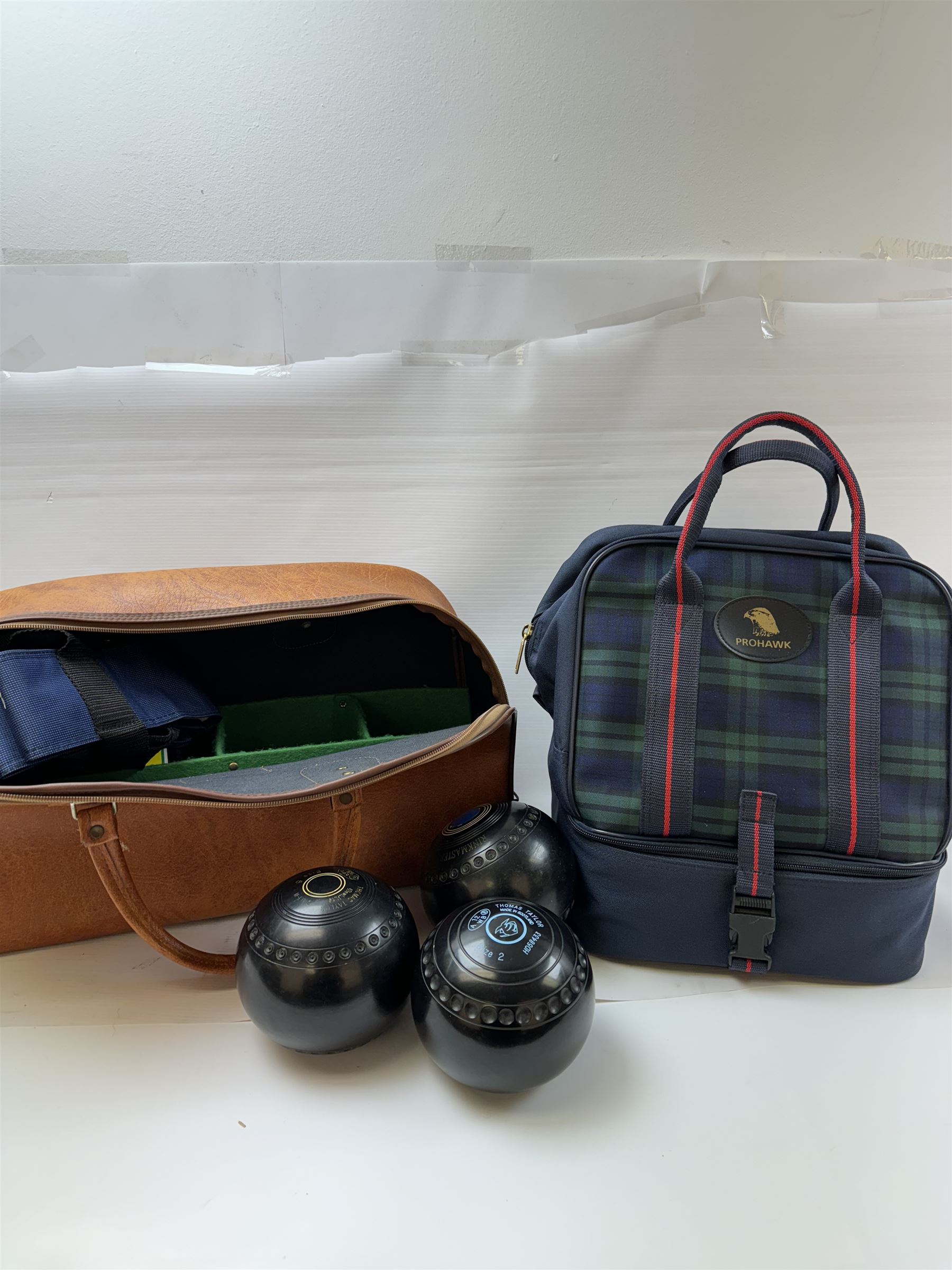 Two sets of flat green bowls, to include a ladies and gentlemans set, both contained within bowling bags