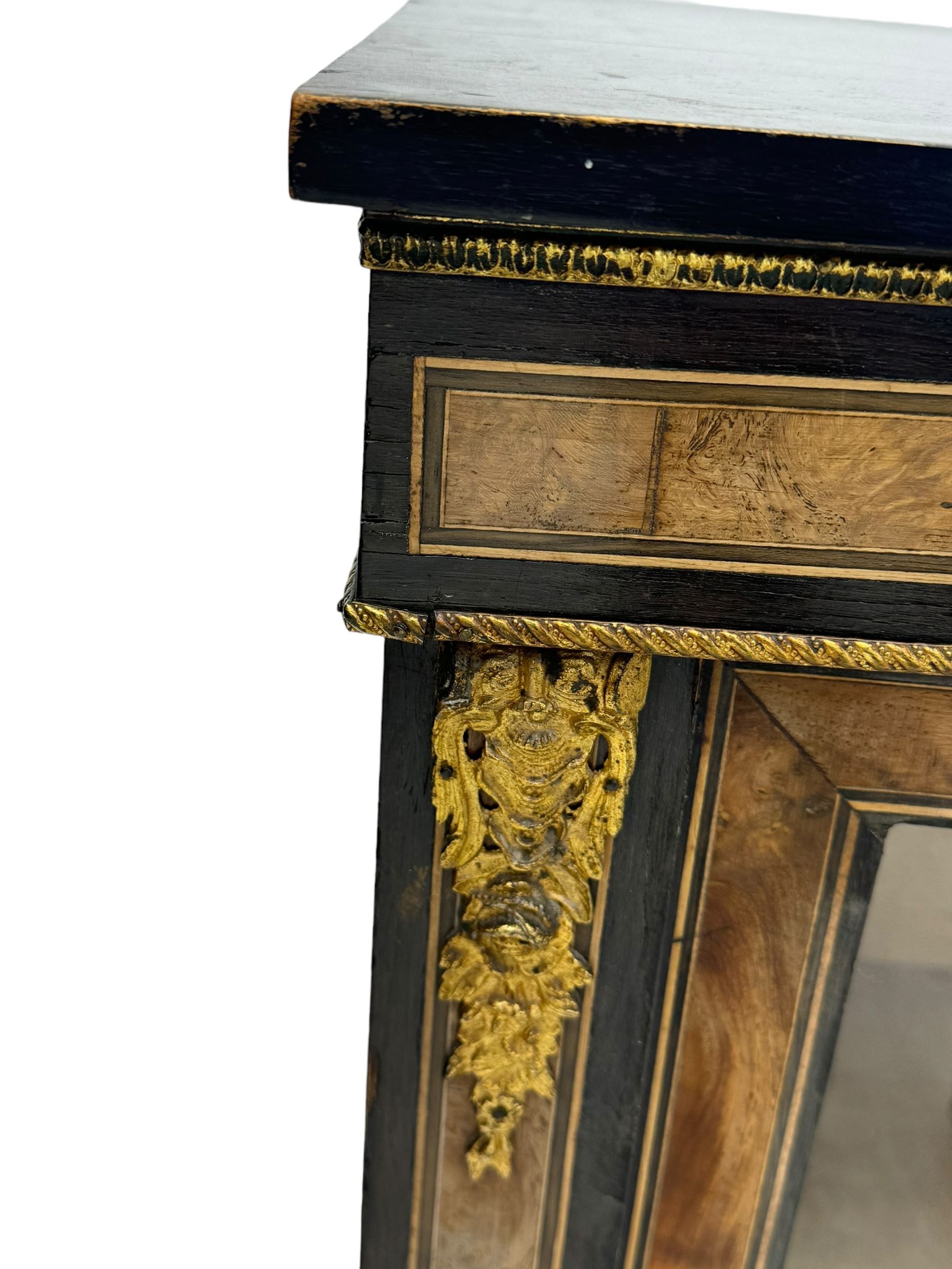 Victorian ebonised and walnut pier cabinet, rectangular top over figured frieze with central star motifs, enclosed by single glazed door, decorated with cast gilt metal mounts and beading, on chamfered plinth base 