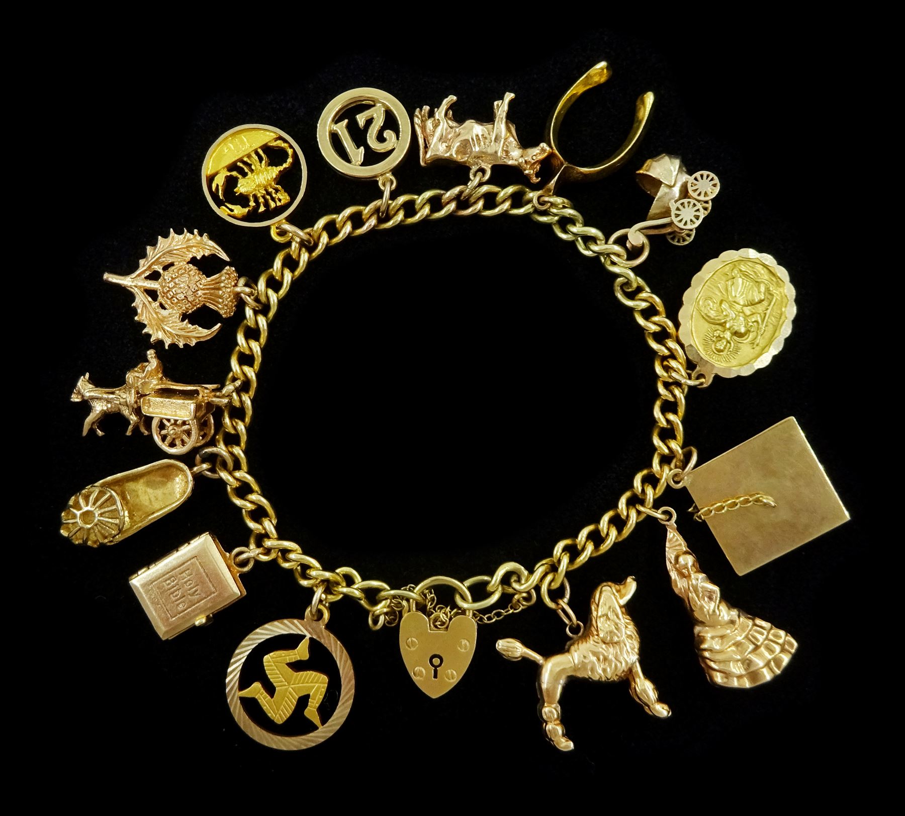 9ct gold curb link chain bracelet, with heart locket clasp and thirteen 9ct gold charms including Georg Jensen St Christopher, Scottish thistle, pony and trap, wishbone, Scorpio, and cow and a 17ct gold Spanish flamenco dancer 