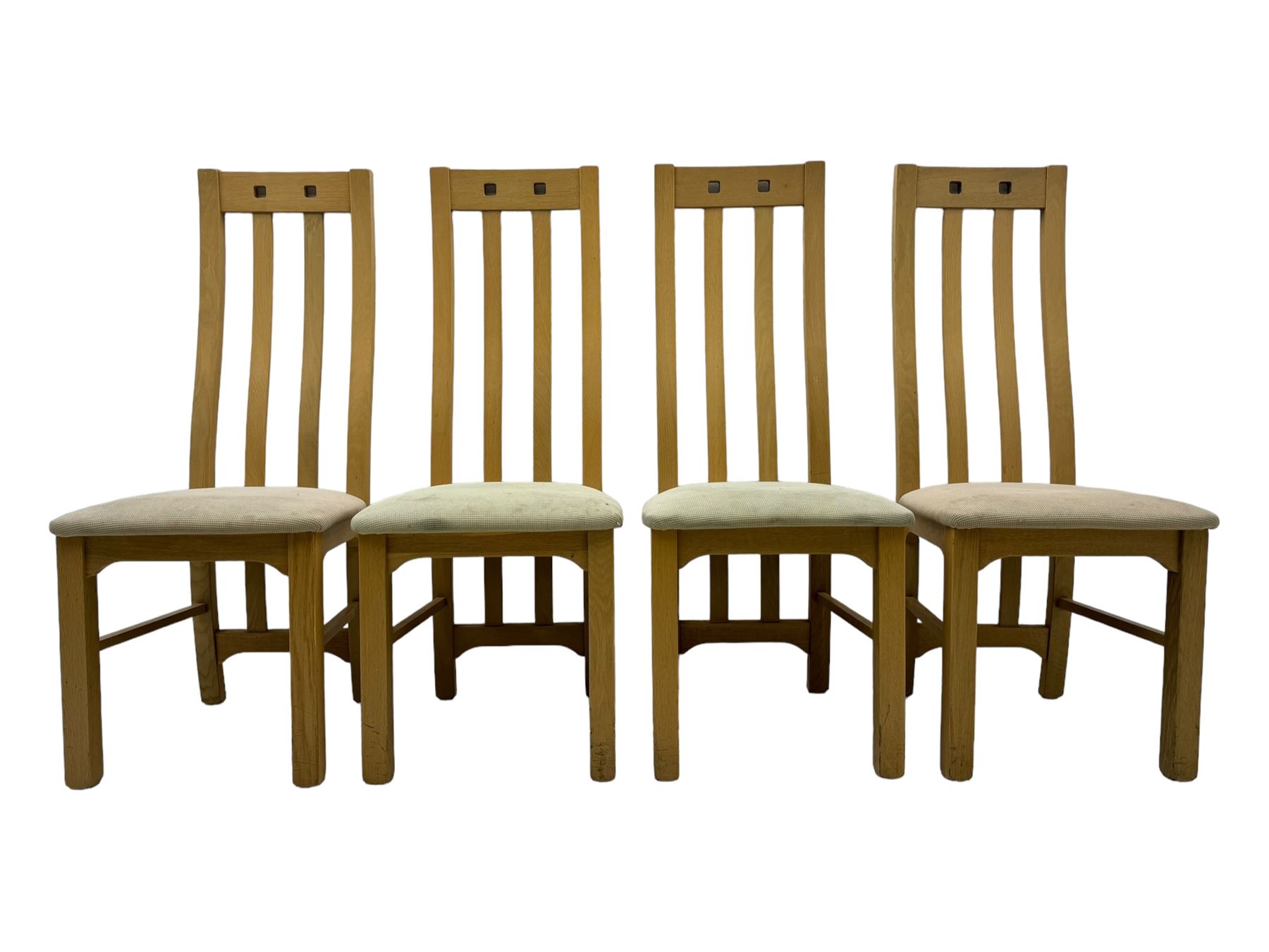 Contemporary set of four oak dining chairs, tall slatted curved backs with square cutouts to the top, upholstered seats in light fabric, on square front supports