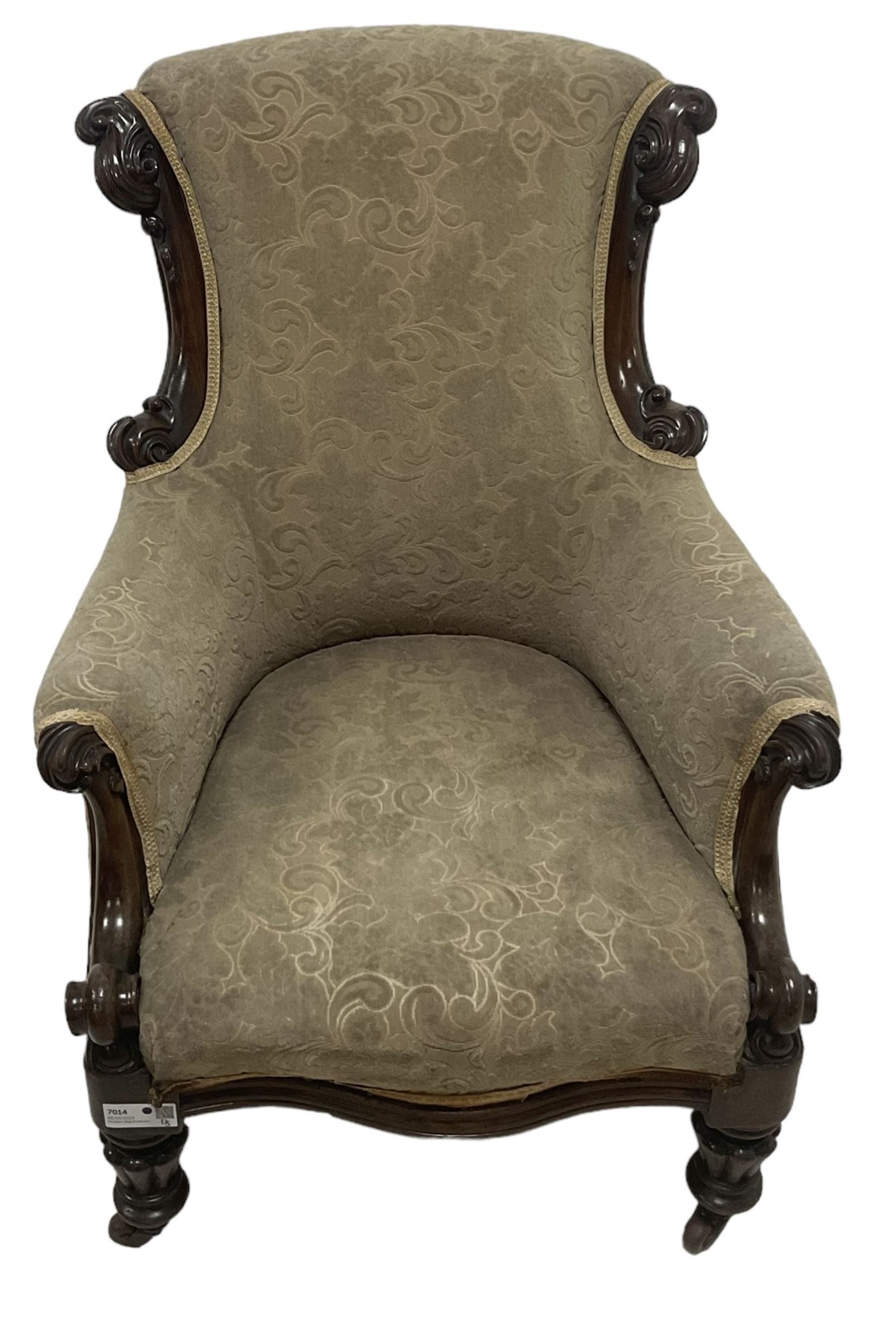 William IV mahogany framed armchair, rolled back with scroll carved uprights, acanthus carved arm terminals over serpentine fronted seat, raised on turned and lobe carved supports with castors