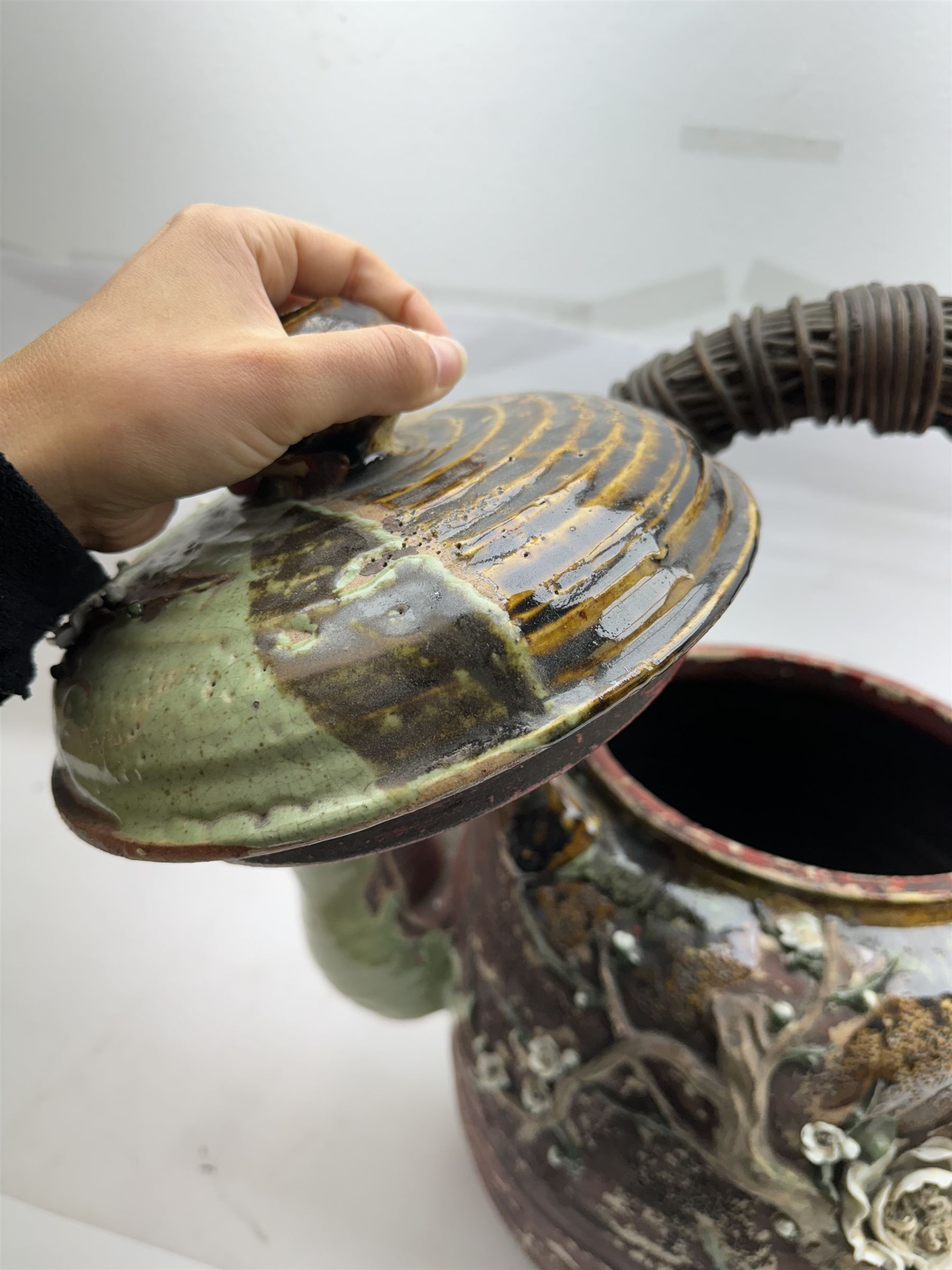 Very large Japanese Shigakari type coil built teapot, the body with a blossoming encrusted tree, woven loop handle and part green glazed spout and cover, H52cm