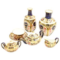 Royal Crown Derby miniature tea set of oval design decorated in Imari design 6299 comprising teapot, two handled sucrier and cover, milk jug and cup and saucer, date code 1905/6 and two small vases pattern 1129, date code 1907 H8.5cm