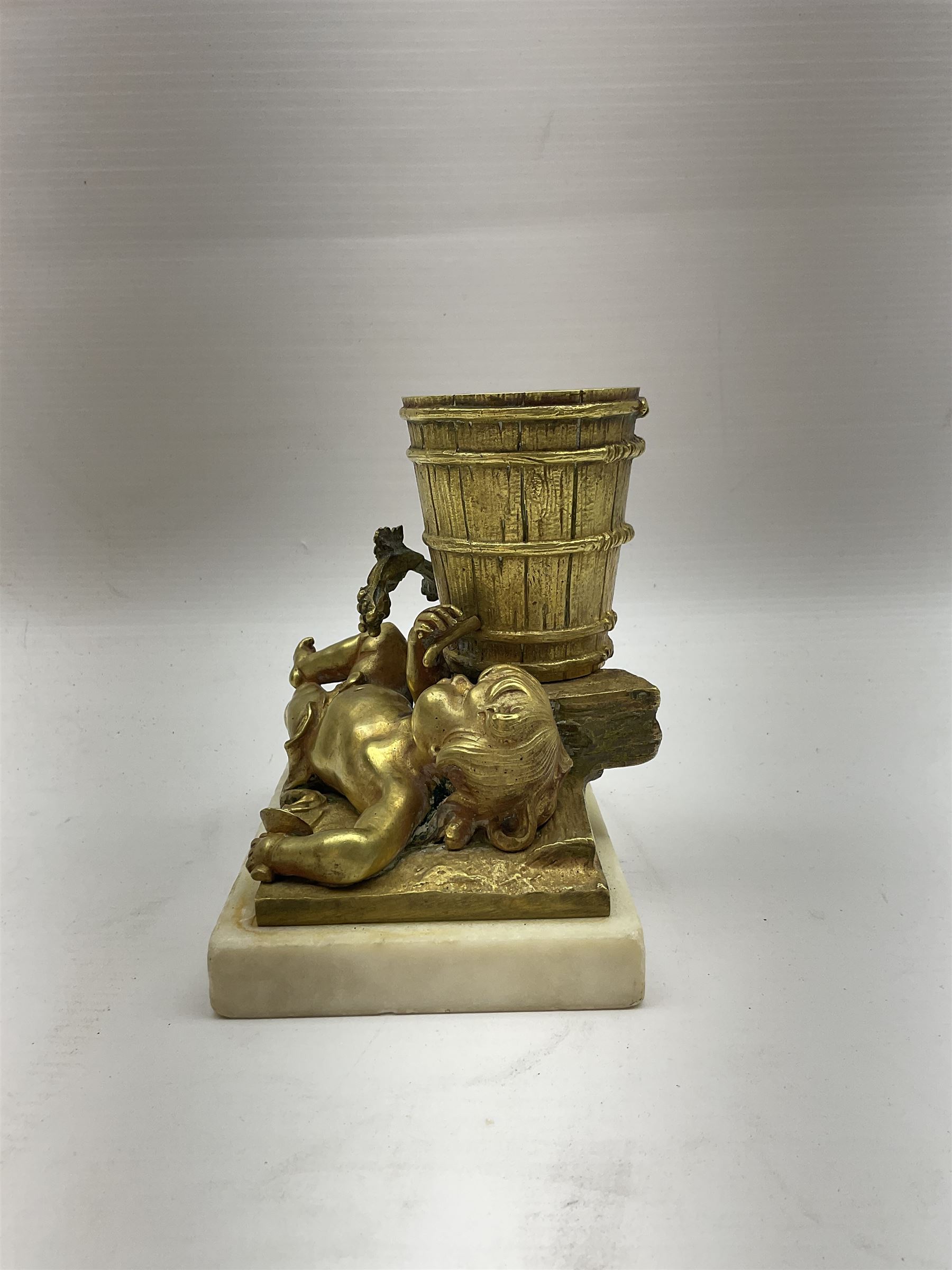 Gilt metal spill vase, the vase modelled as a a barrel with putti amongst fruiting vines laid before, upon rectangular base and rectangular marble plinth, H13.5cm