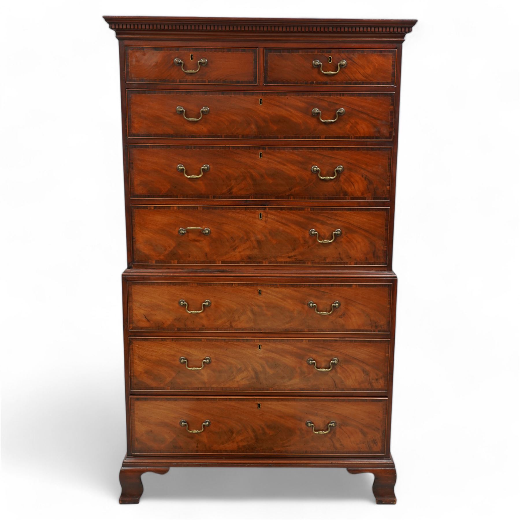 George III mahogany chest-on-chest, projecting moulded and dentil cornice, fitted with two short over six long graduating cock-beaded drawers, each with mahogany band and checkered stringing, brass swan neck handles and circular plates, on ogee bracket feet