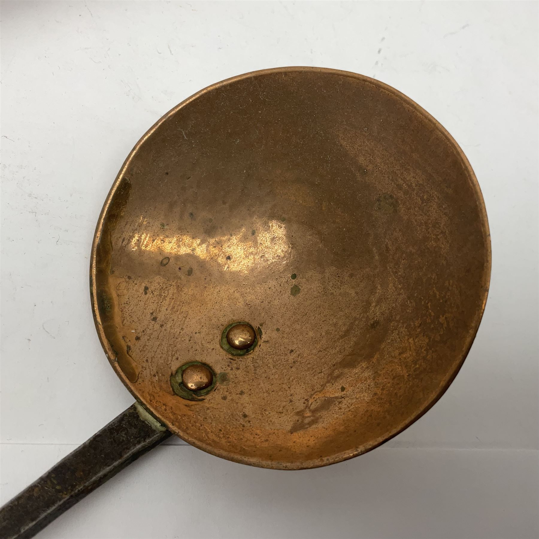 Large 19th century copper slotted spoon, with pierced flat bowl, L55cm, together with two 19th century iron handled ladles with circular copper bowls, largest example L48.5cm, (3)