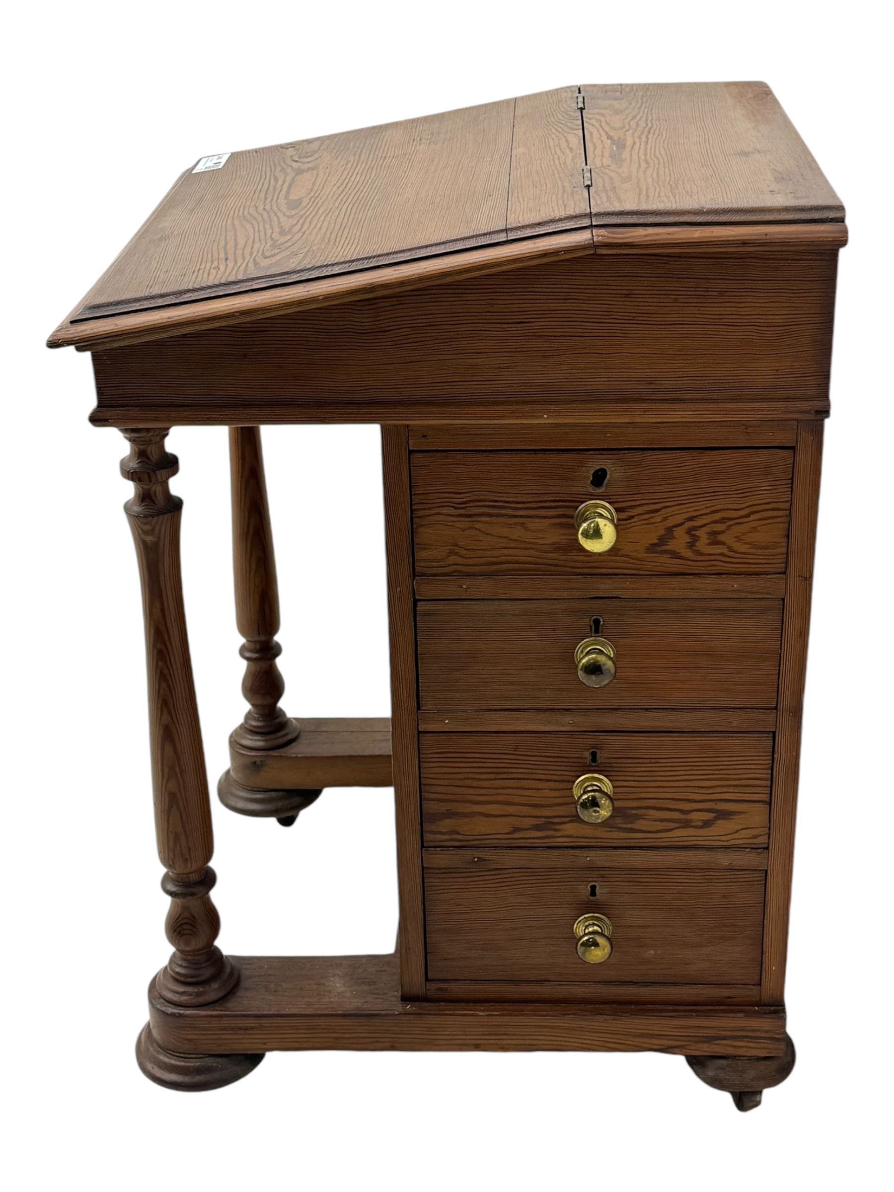 19th century pitch pine Davenport desk, sloping hinged top, fitted with four drawers, on turned column supports, turned compressed feet with castors 