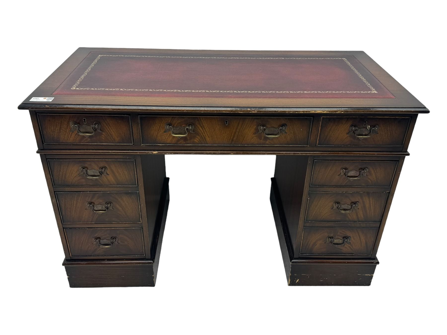 20th century mahogany twin pedestal desk, moulded rectangular top with red leather inset with gilt tooled border, central drawer over kneehole flanked by two banks of four graduating cockbeaded drawers, on plinth base